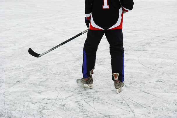 Giocatore di hockey con bastone e disco sul ghiaccio. - Foto, immagini