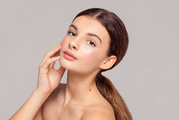 health and beauty concept - Beautiful Young Woman with Clean Fresh Skin touch own face . Facial treatment . Cosmetology , beauty and spa . - Zdjęcie, obraz