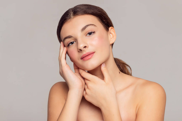 health and beauty concept - Beautiful Young Woman with Clean Fresh Skin touch own face . Facial treatment . Cosmetology , beauty and spa . - Valokuva, kuva