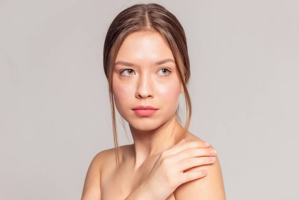 health and beauty concept - Beautiful Young Woman with Clean Fresh Skin touch own face . Facial treatment . Cosmetology , beauty and spa . - Photo, Image