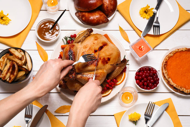 Woman eating traditional cooked turkey at white wooden table, top view. Thanksgiving day celebration - Фото, зображення