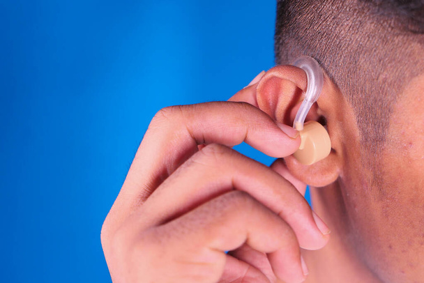 Concepto de audífono, un joven con problemas auditivos. - Foto, imagen
