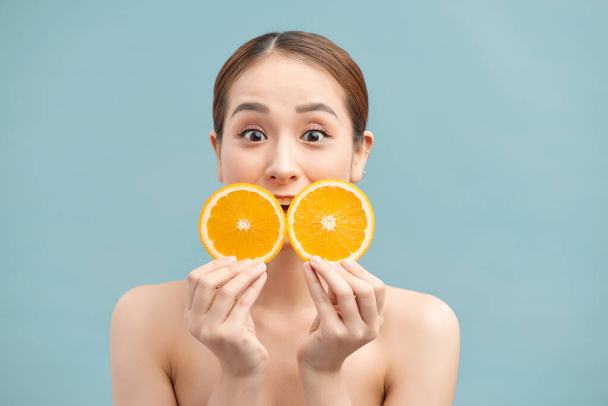 Ładna śmiejąca się dziewczyna w pomarańczowych plasterkach przed jej okiem - Zdjęcie, obraz