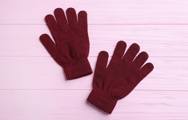 Stylish gloves on pink wooden background, flat lay - Foto, imagen