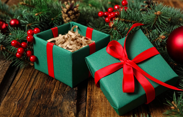 Green Christmas gift box with red bow on wooden table - Fotoğraf, Görsel