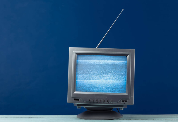 Mini Retro tv antenni vastaanotin klassisella sinisellä taustalla. Vanhanaikainen televisio. Televisioääni, ei signaalia. 80-luku - Valokuva, kuva