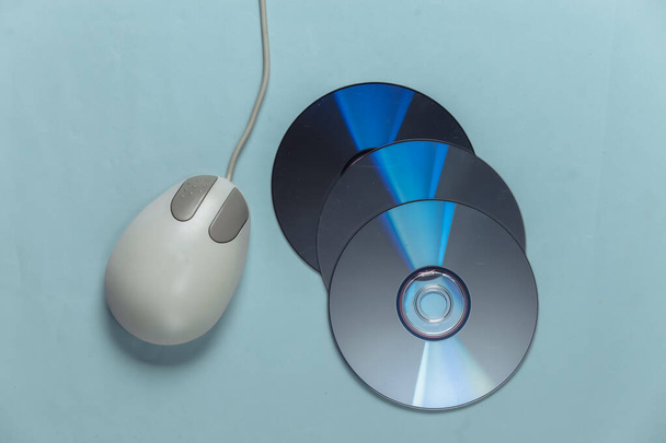 Vieux CD rétro et souris PC sur fond bleu pastel. Vue du dessus - Photo, image