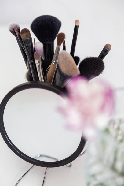 Verschiedene Artikel für Schönes Make-up. Kosmetik mit Spiegel und Blume - Foto, Bild