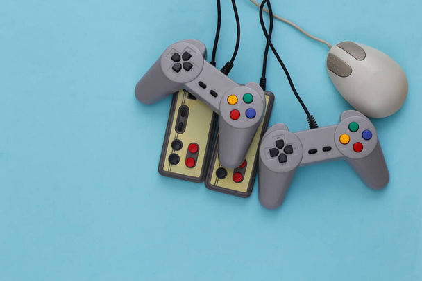 Retro joysticks en pc muis op blauwe achtergrond. Retro gaming, gaming apparaten, gadgets - Foto, afbeelding