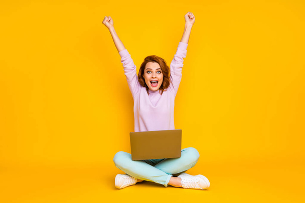 Full length photo of delighted crazy woman sit floor legs crossed folded work laptop win lottery raise fists scream yeah wear pink teal trousers sneakers isolated over bright color background - Foto, Bild