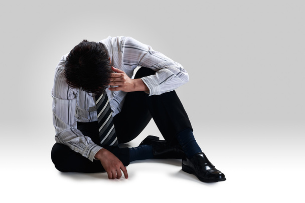 Stressed disappointed businessman sitting alone on floor - Photo, Image