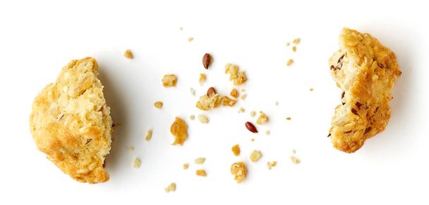 Разбитые овсяные хлопья печенье с семенами изолированы на белом фоне, вид сверху - Фото, изображение
