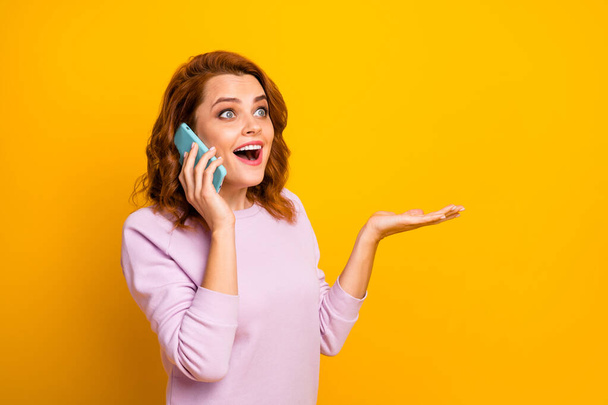 Photo of funny excited lady hold telephone hand talking to best friend saying listening fresh news gossips rumors wear pink pullover isolated yellow color background - Φωτογραφία, εικόνα