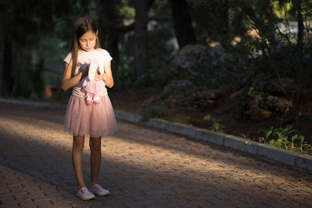 Surullinen valkoihoinen tyttö halaamassa lelua. Lapsi syleilee pehmeä pehmo karhu puistossa ulkona. Kadonnut yksinäinen lapsi ulkona. Onnettomat lapsuuden ongelmat elämäntapa - Valokuva, kuva