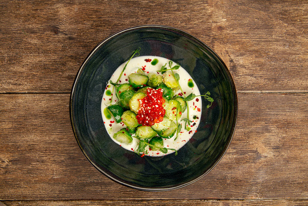 Brussels sprouts with caviar in a black bowl - Foto, afbeelding