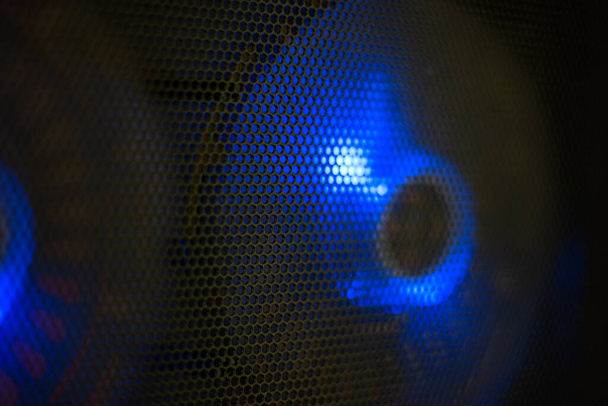 Blaue LED-Beleuchtung PC Computer Lüfter hinter schwarzem Drahtgeflecht Nahaufnahme flache Schärfentiefe. - Foto, Bild