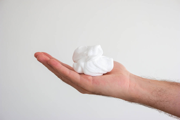 Caucasian male hand holding whipped shaving foam close up shot isolated. - Foto, Imagen