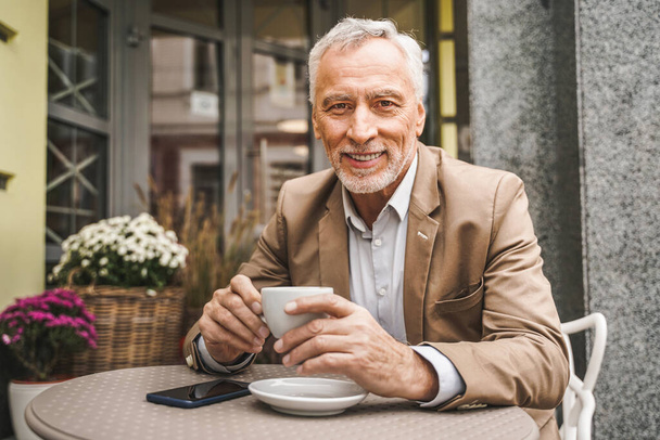 Cheerful senior man portrait. Mature adult sitting in a caf restaurant outdoors - Zdjęcie, obraz