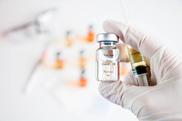 Wirus Corona i Covid - 19 nowych szczepionek w ampułkach i butelkach, igły i ręce lekarzy z rękawiczkami. - Zdjęcie, obraz