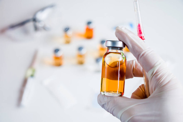 Vírus da Corona e Covid - 19 nova vacina em ampolas e frascos, agulha e mãos de médicos com luva. - Foto, Imagem