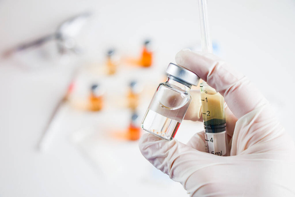 Вірус Корони і Ковід - 19 нова вакцина в ампутаціях і пляшках, голка і лікарі вручають рукавичці. - Фото, зображення