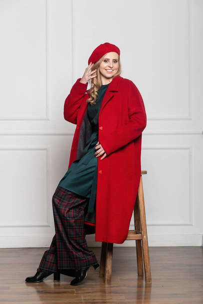 fashion and glamour concept - stylish woman in a beret and coat on a light background. coat, beret, clothes, style, fashion, beauty, young woman - 写真・画像