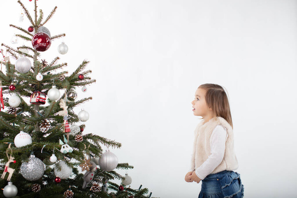 Fasciné tout-petit fille regardant vers le haut vers l'arbre de Noël - Photo, image