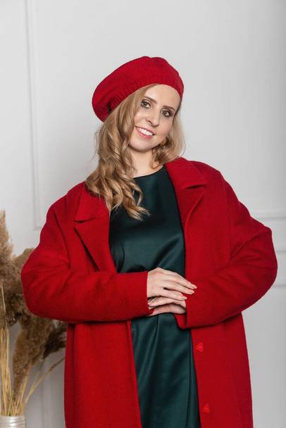 fashion and glamour concept - stylish woman in a beret and coat on a light background. coat, beret, clothes, style, fashion, beauty, young woman - Fotoğraf, Görsel