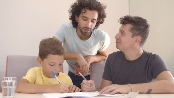 Twee vaders helpen zoon met schrijven taak - Video