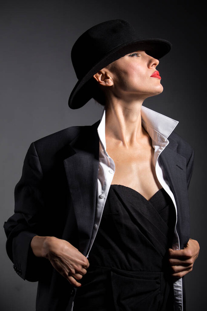 Portrait of a beautiful woman in a hat and boyfriend oversize huge suit. retro woman - Foto, Bild