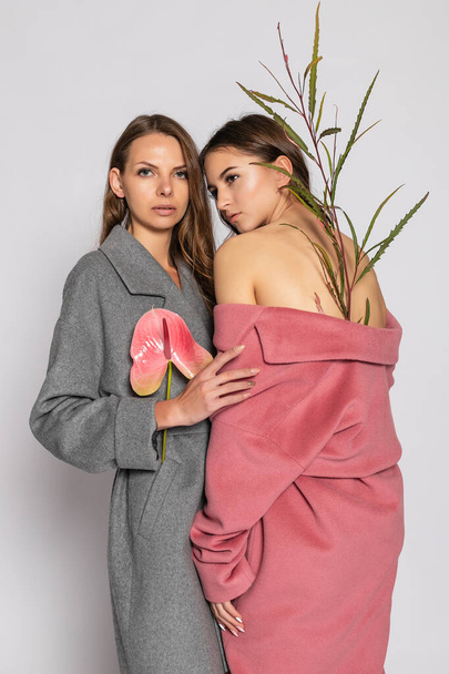 fashion portrait of two smiling brunette women models in summer casual hipster overcoat posing on gray background. Full length. - Foto, afbeelding