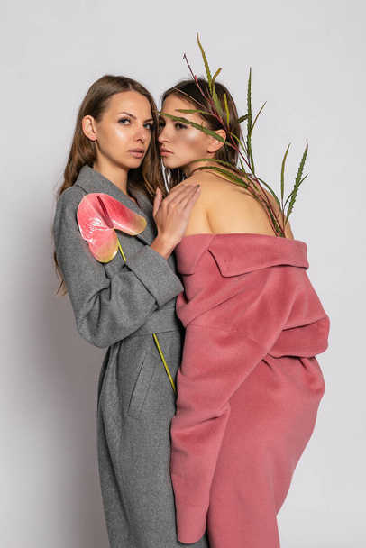 fashion portret van twee lachende brunette vrouwen modellen in de zomer casual hipster overjas poseren op grijze achtergrond. Totale lengte. - Foto, afbeelding