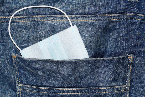 beschermend medisch masker in jeans pocket close up - Foto, afbeelding