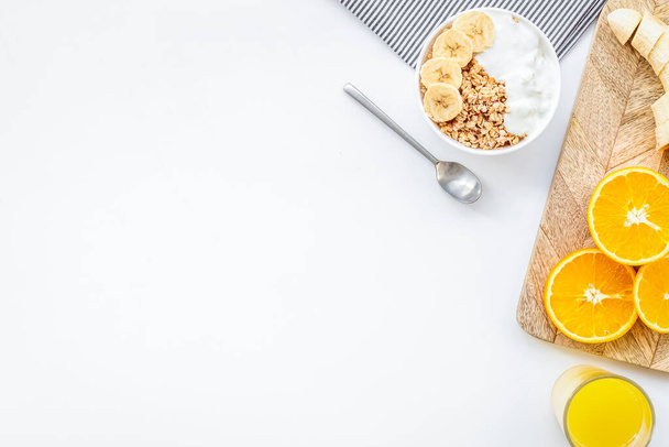 granola con fette di banana e succo d'arancia per la prima colazione su sfondo blu vista dall'alto copyspace - Foto, immagini