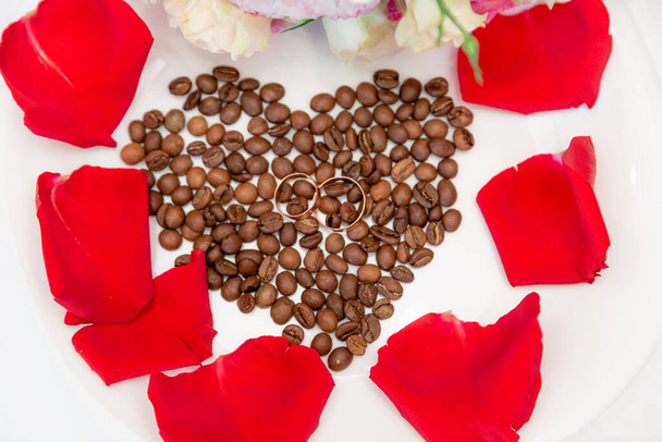 Heart of coffee beans with rose petals. - Fotoğraf, Görsel