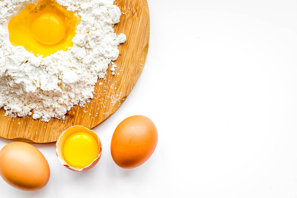 Making dough concept. Pile of flour and eggs on white background top view space for text - Фото, изображение