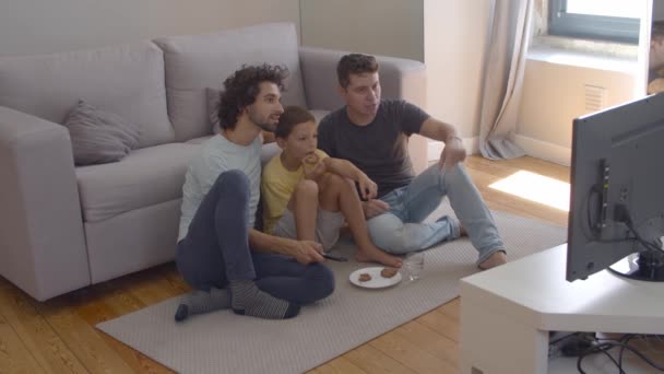 Enfocado chico y su papás comiendo galletas y viendo película - Metraje, vídeo