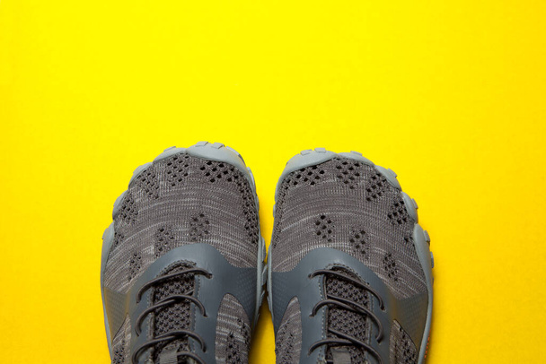 Sport gray sneakers isolated on yellow background - Фото, зображення