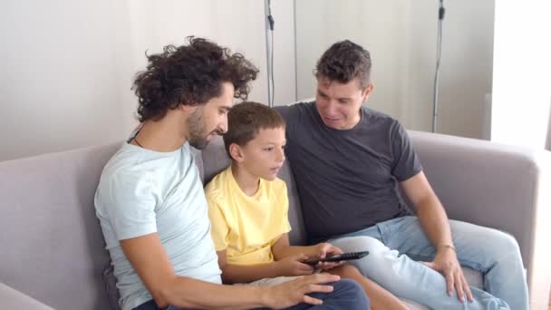 heureux gay parents et fils assis ensemble sur canapé - Séquence, vidéo