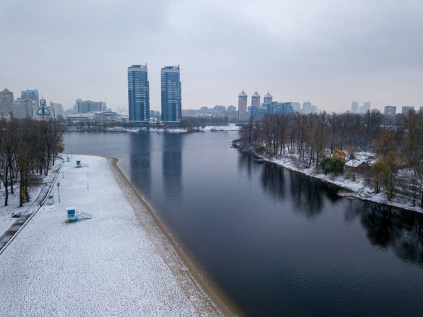 Luchtdrone zicht. Met sneeuw bedekte stadsstrand in Kiev. Een dun laagje van de eerste sneeuw op het zand. - Foto, afbeelding
