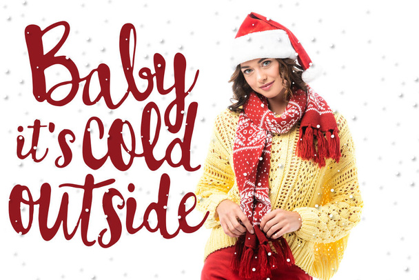 young brunette woman in santa hat touching red scarf near baby its cold outside lettering on white  - Foto, afbeelding