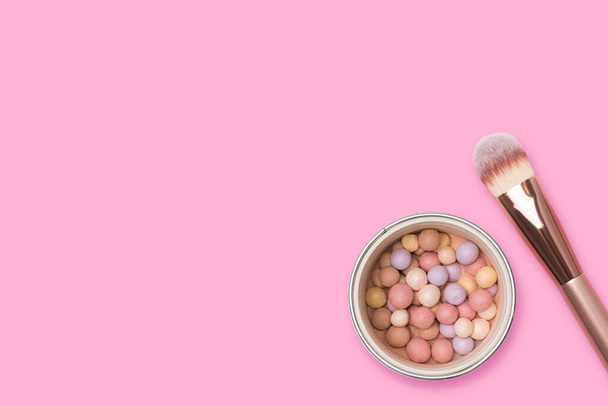 Face powder and brush on a pink background. Meteorites for makeup - Foto, Imagem