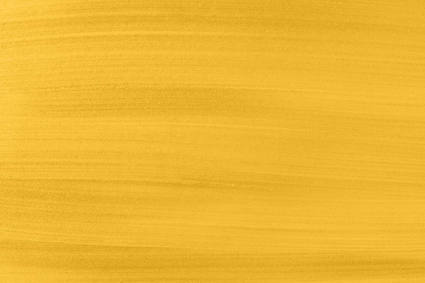 Background or texture with golden paint. Acrylic gold paint abstract texture or painting for your banner or poster. Banner toned in trendy 2021 color - Foto, immagini