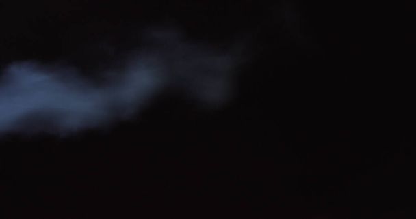 Humo atmosférico efecto niebla 4K. Humo en cámara lenta sobre fondo negro. Humo blanco flotando lentamente a través del espacio contra fondo negro - Foto, imagen