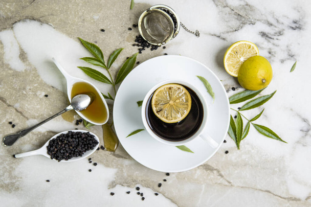 A cup of tea, honey, and lemons. Elderberries. - Photo, Image