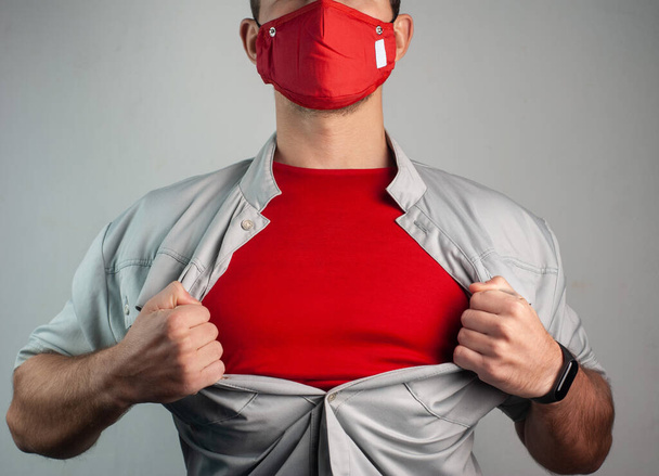 Superhéroe en una máscara médica rasga la camisa en el pecho - Foto, Imagen
