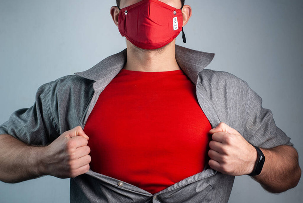Super man in red medical mask rips shirt on chest - Foto, Bild