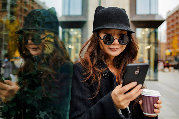 Vásárló nő vásárol online Smart Phone a City Street télen. - Fotó, kép