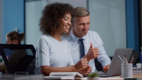 Biznesmen i businesswoman pokazuje kciuki do góry podczas rozmowy wideo na laptopie - Materiał filmowy, wideo