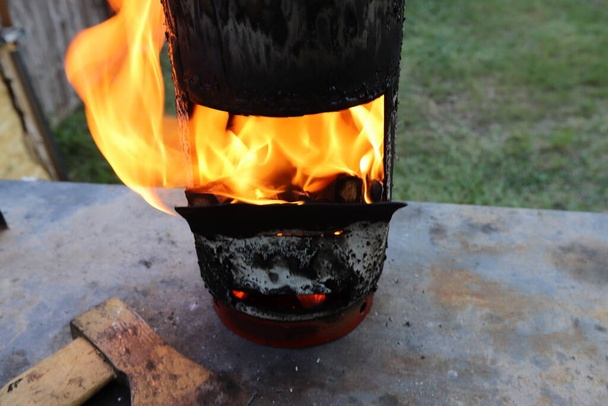 Queimar lenha com uma chama brilhante em uma grade de ferro depois de incendiar a fritura de kebabs de carne. Um piquenique em uma clareira florestal  - Foto, Imagem